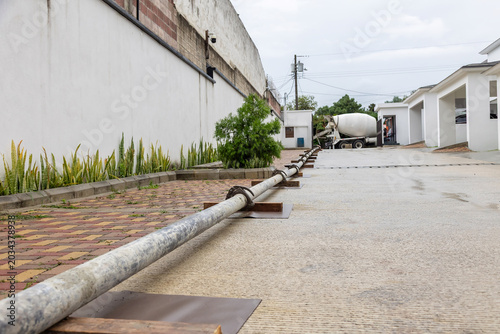 Long concrete pumping pipeline connected to mixer truck for residential slab pouring and reinforced concrete construction work