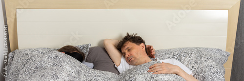 Fotografía A fifty-year-old couple sleeps side by side in their bedroom at night