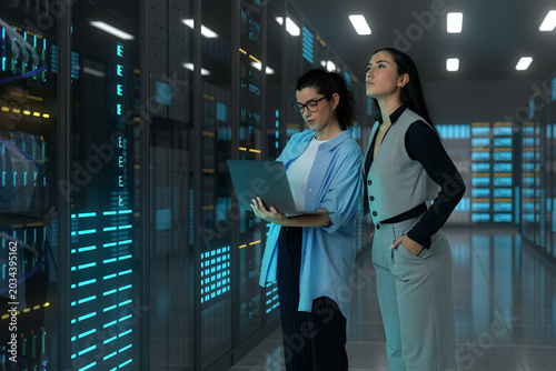Women engineers monitoring server infrastructure in a 3D data center