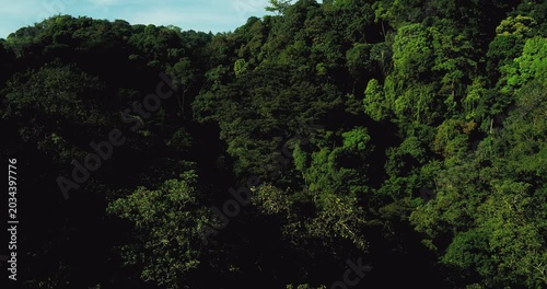 Cinematic aerial view of jungle mountains with glowing sunlight and haze