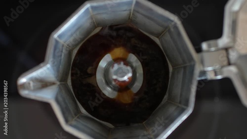 Close-up top view of moka pot filling in with coffee