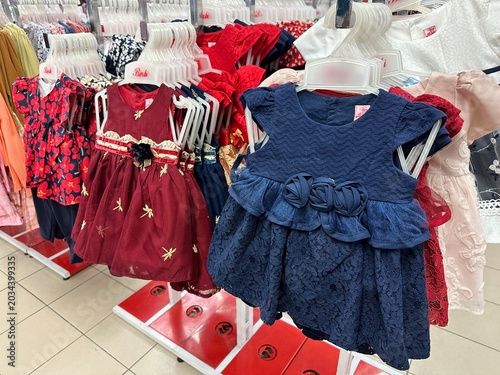 Assorted Toddler Girl Dresses on Clothes Hangers in Retail Shop
