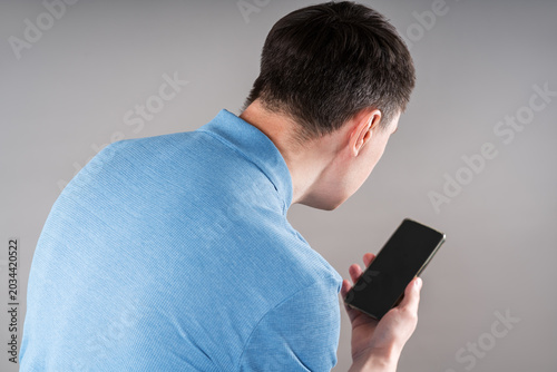 Man with neck pain from using smartphone, text neck and bad posture concept