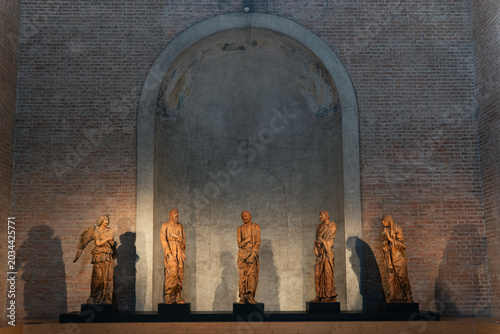 Foto Five wooden angel statues displayed in an arched brick alcove