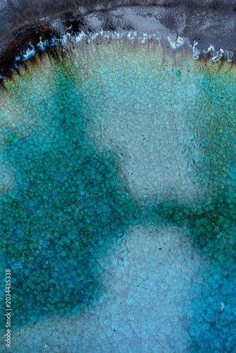 Cracked ceramic glaze showing an abstract pattern of blue and green colors