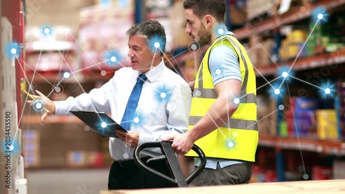 Manager pointing at clipboard activating overlay linking to warehouse racks worker readying to pick