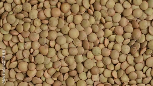 A top-down, close-up shot of dry green lentils slowly rotating. Perfect for themes related to healthy eating, vegan food, agriculture, and organic ingredients.
