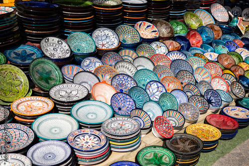 Colorful artisanal ceramic plates and bowls at a Moroccan market