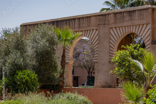 Traditional Moroccan arches in a peaceful public garden with green trees