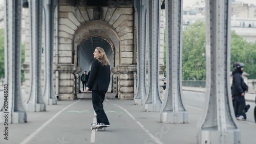 Young businessman skateboarding on pont de bir-hakeim in paris