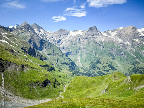 Jagged alpine peaks with snow patches and green valley