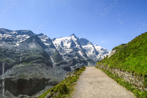 Foto Stone walled hiking path leading toward glaciated peak