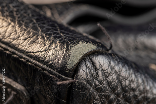 Fotografie details of a natural black leather bag after prolonged use, dark color