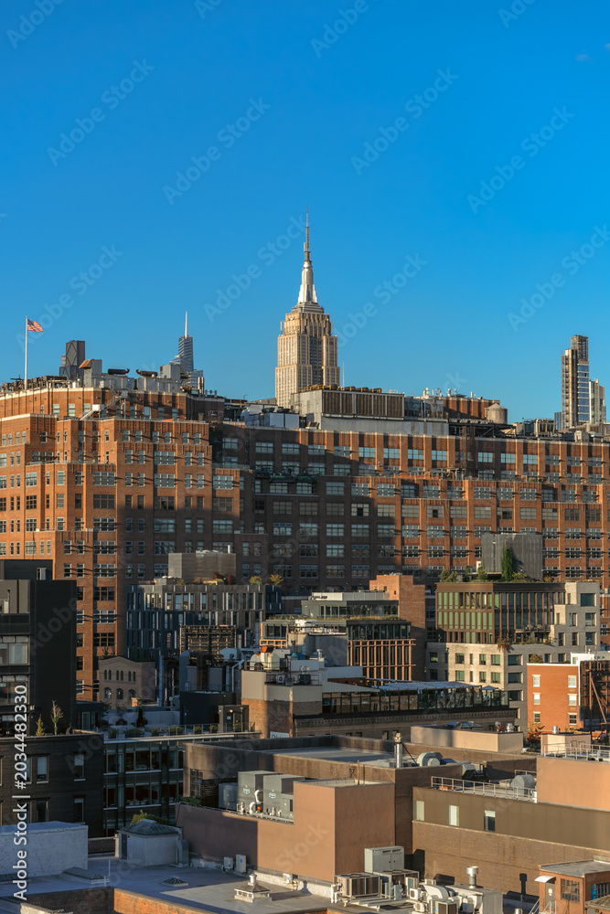 Obraz premium Empire State Building Rising Above Manhattan Rooftops at Golden Hour