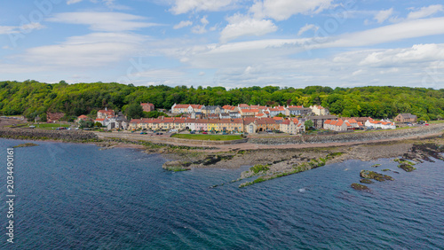 Canvas Print Wide panoramic view of the historic coastal village of West Wemyss in Fife, Scotland, with traditional colourful houses and stone sea wall along the shore