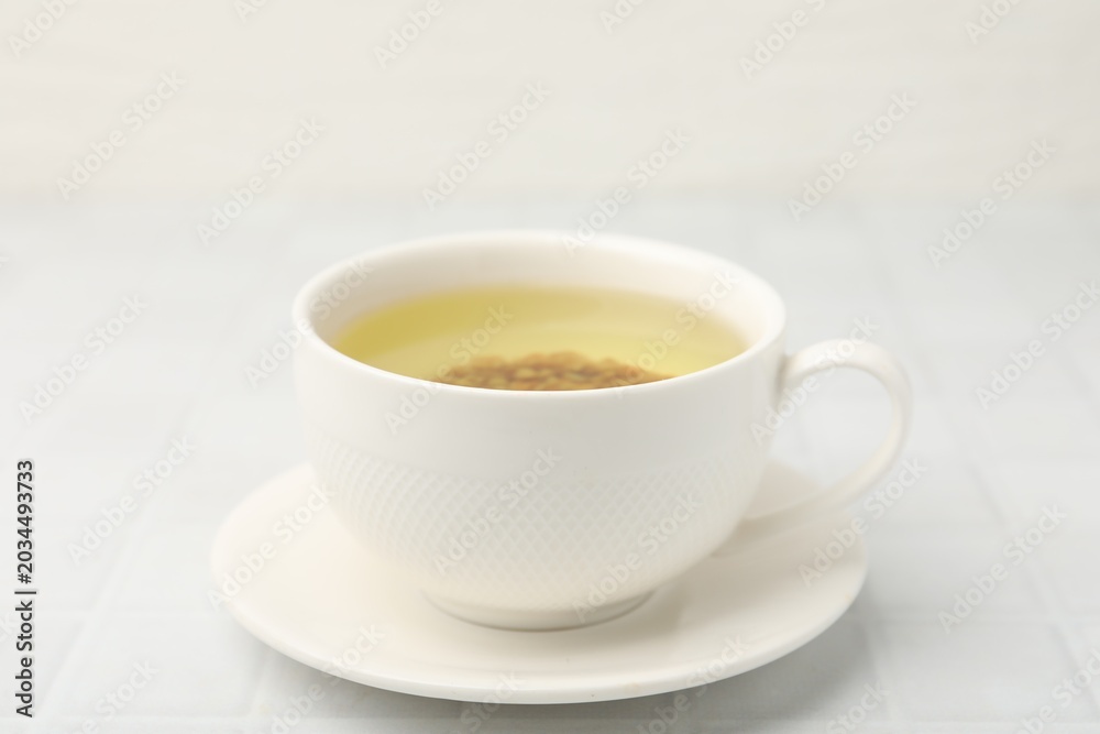 Obraz premium Buckwheat tea in cup on white tiled table, closeup