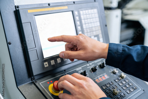Tableau sur toile Operator uses touchscreen and buttons on industrial control panel for manufactur