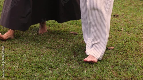 Two barefoot women walking on grass earth connection outdoor concept