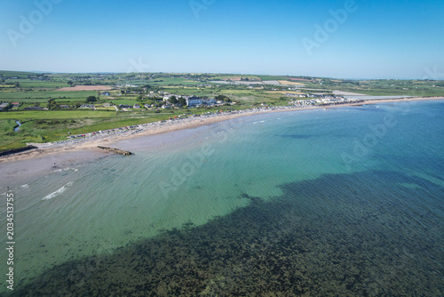 Drone aerial view of Garryvoe Beach in County Cork, Ireland on a bright sunny day with clear blue skies and calm coastal scenery.
