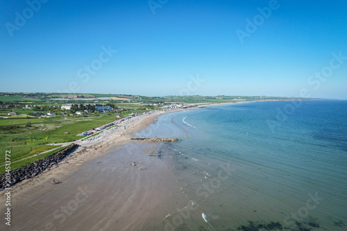 Drone aerial view of Garryvoe Beach in County Cork, Ireland on a bright sunny day with clear blue skies and calm coastal scenery.