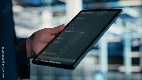Canvas Print Close up of data center engineer using tablet to write code, compiling software patches to fix bugs, Server farm IT professional using device application to run programming script, camera B