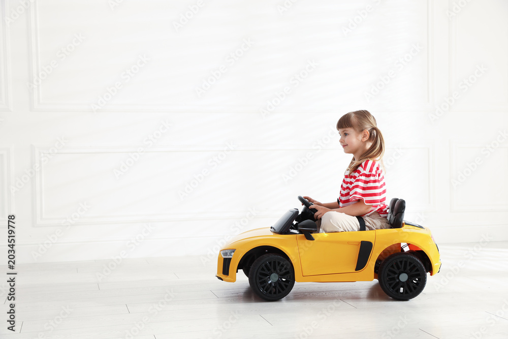 Fototapeta premium Little child driving toy car at home, space for text