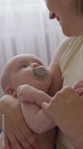Gentle maternal bond. Calm morning moment with mother and infant peacefully interacting on bed. Mom engages with her baby through affectionate play. happy domestic motherhood routine in cozy home