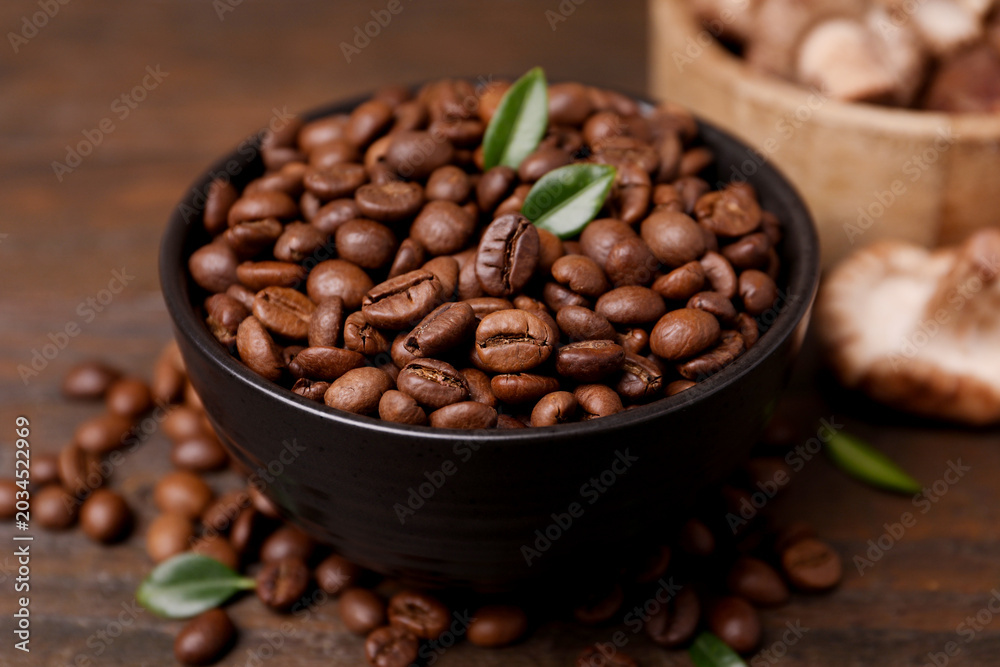 Fototapeta premium Coffee beans and mushrooms on wooden table, closeup