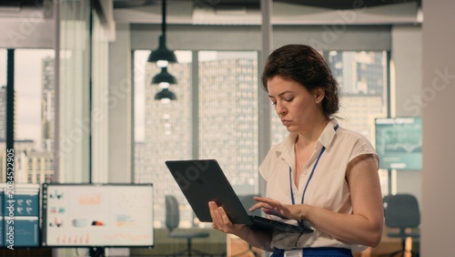 Valokuva Pacing the floor, agitated nervous woman, repetitive fidgeting, back and forth, nervousness at work, task management, modern office, multinational company, anxious physical expression