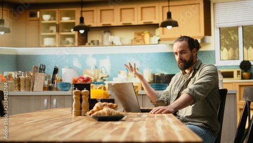 Konstfotografi Confused preoccupied male, uncertain with remote work, laptop working from home, unsure male freelancer frowning at the screen and struggling to solve ambiguous teleworking, man in doubt