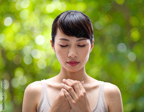 Calm Young Woman Standing with Closed Eyes and Clasped Hands in Green Garden Background