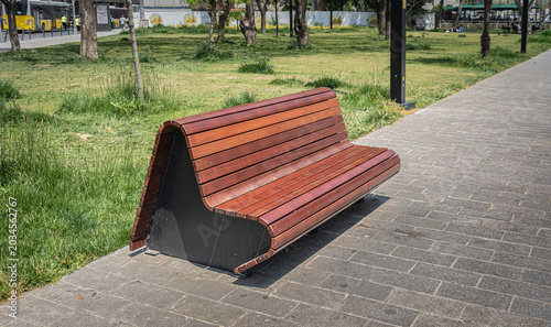 A wooden bench in the park. Bench and pavement.