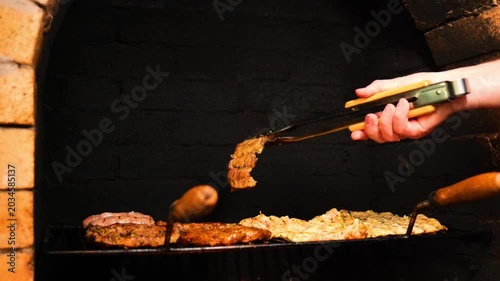 Meat for the Grill. Appetizing, delicious Barbecue and Grill . Pork Steaks, Sausages, and Chicken Breasts on the Grates.Hands turn the meat on the grate in an outdoor oven. footage