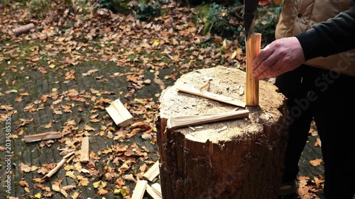 Wood chips for lighting the stove. Heating a house with wood.Man Splitting Wood with Axe Outdoors. 4k footage