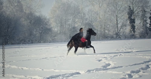 Beautiful woman in red riding horse in winter