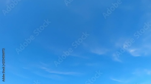 An expansive azure blue sky with wispy white clouds, slowly drifting above pristine pure white copy space, bathed in bright optimistic daylight. Concept of limitless potential and clear vision