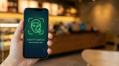 Identity verified mobile screen showing facial recognition login for online scam prevention and secure access in cafe setting