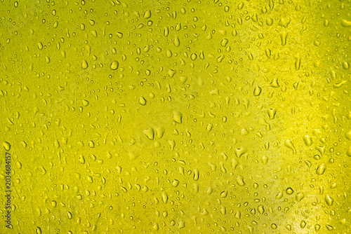 Green yellow tent fabric with raindrops showing water droplets on waterproof material creating romantic tourism background texture