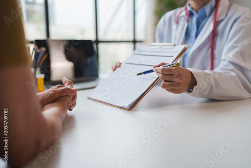 Foto Doctor discussing health assessment form with patient