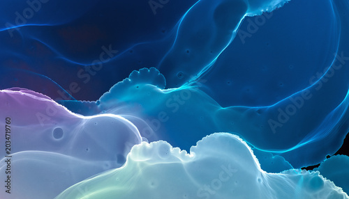 Concept of mysterious deep sea or atmospheric currents depicted through macro photography of smooth glowing cyan and dark blue fluid textures with striking luminescent edge lighting against black.