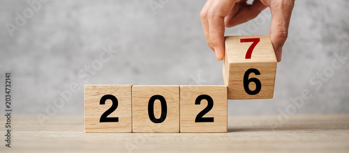 Photos hand flipping block 2026 to 2027  text on table