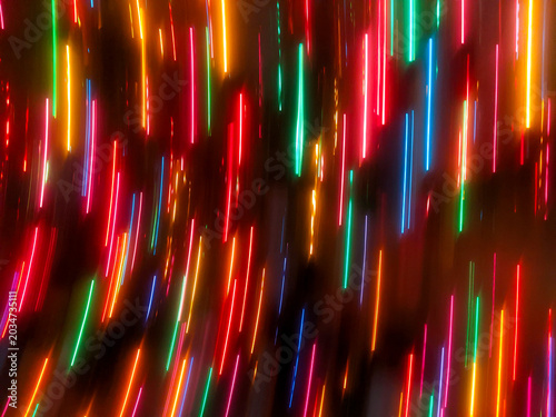 Obraz na płótnie An abstract, full-frame intentional camera movement (ICM) shot showing vibrant red, orange, green, and blue holiday lights blurred into bright vertical streaks against a dark backdrop