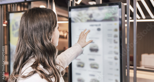 Cuadro en lienzo Woman interacting with digital touchscreen menu in restaurant, intuitive interfa