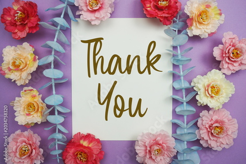Foto Thank You text written on paper card with flowers decoration