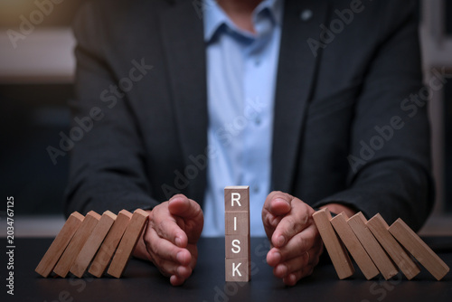 Cuadro en lienzo Focused businessman taking proactive action to stop falling dominoes for success