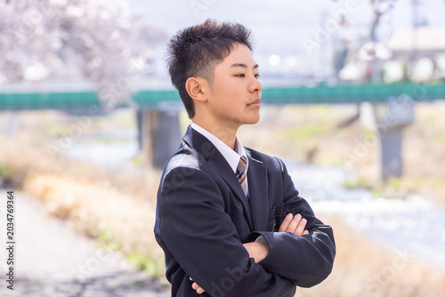 Fotografie 腕を組み堂々と立つ男子学生