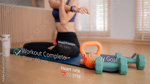 Asian women fitness workout home using smartwatch tracking heart rate blood pressure calorie burn with augmented reality display exercise mat dumbbell