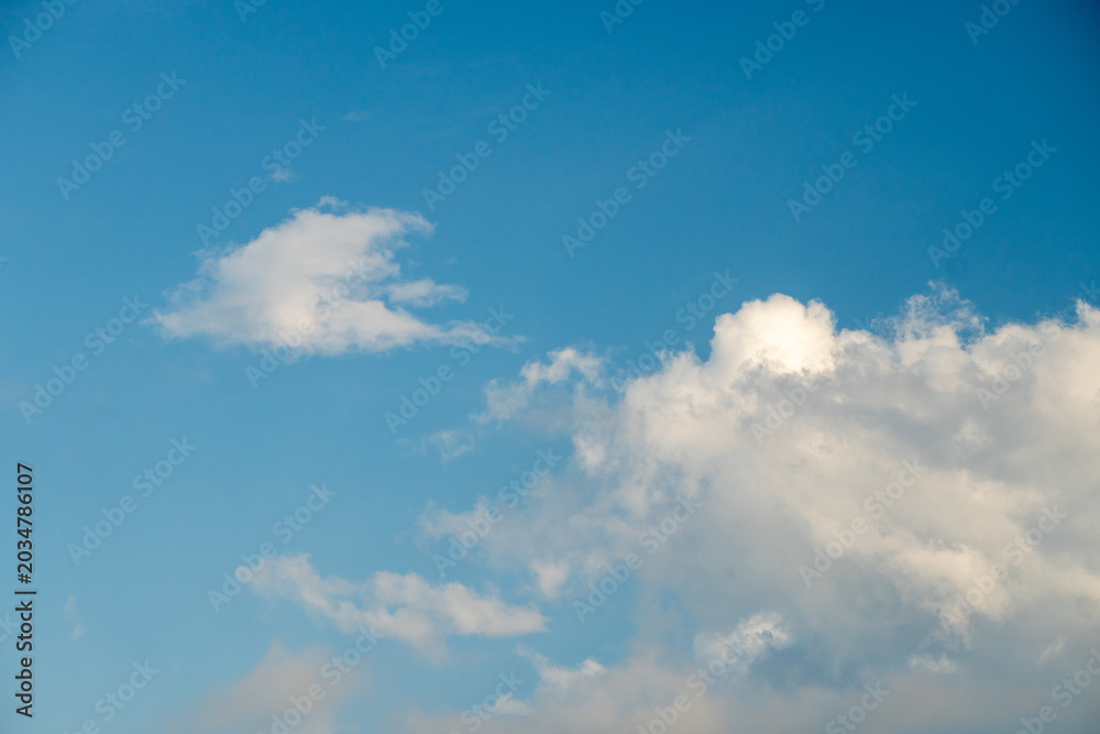 Fototapeta premium Bright blue sky filled with fluffy white clouds, often used as a natural backdrop. clear blue sky alongside scattered white cumulus clouds.