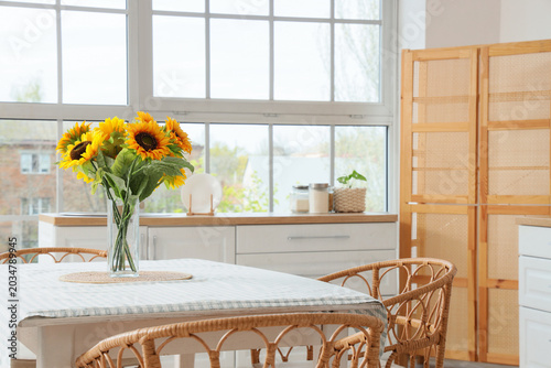 Vase with sunflowers on din...