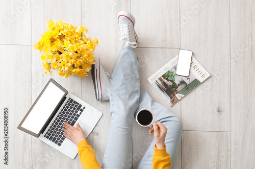 Woman with coffee cup using...